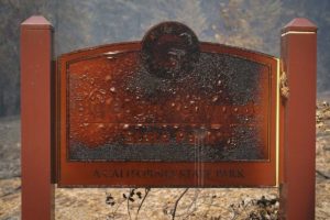 A wildfire-damaged sign welcomes visitors Monday, Aug. 24, 2020, in Big Basin Redwoods State Park, Calif.